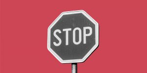 A grayscale STOP sign on a red background