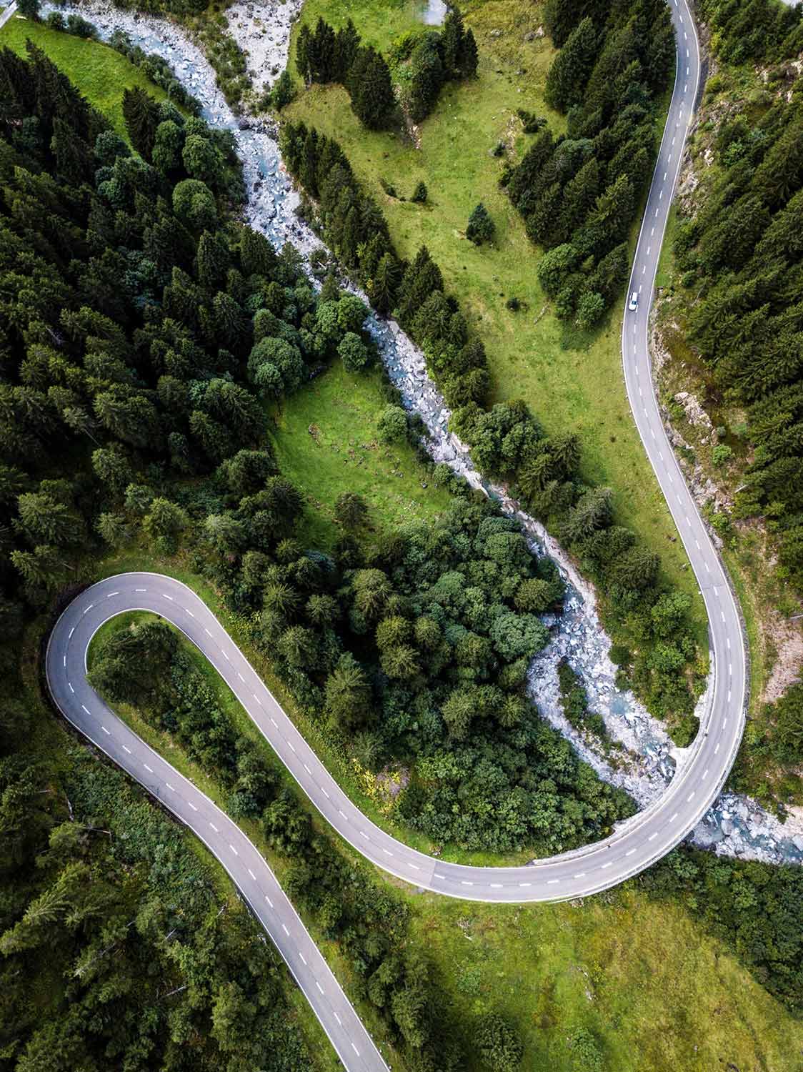 ludovic-fremondiere-386791-scaled Aerial view of a road with a sharp, hairpin turn, winding across green landscape